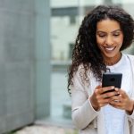 Young woman walking through town using a mobile