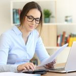 Woman Wearing Eyeglasses Working Calculating With A Calculator A
